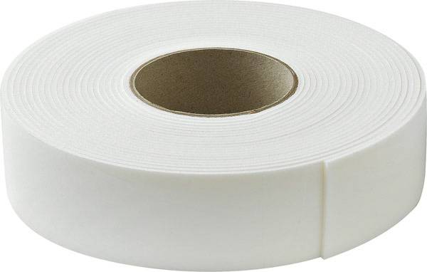 Un rouleau de ruban adhésif blanc sur une table, prêt à être utilisé.