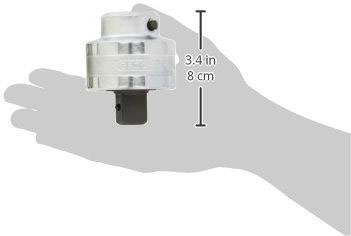 Adaptateur métallique compact, hauteur de 8 cm, tenu dans une main.