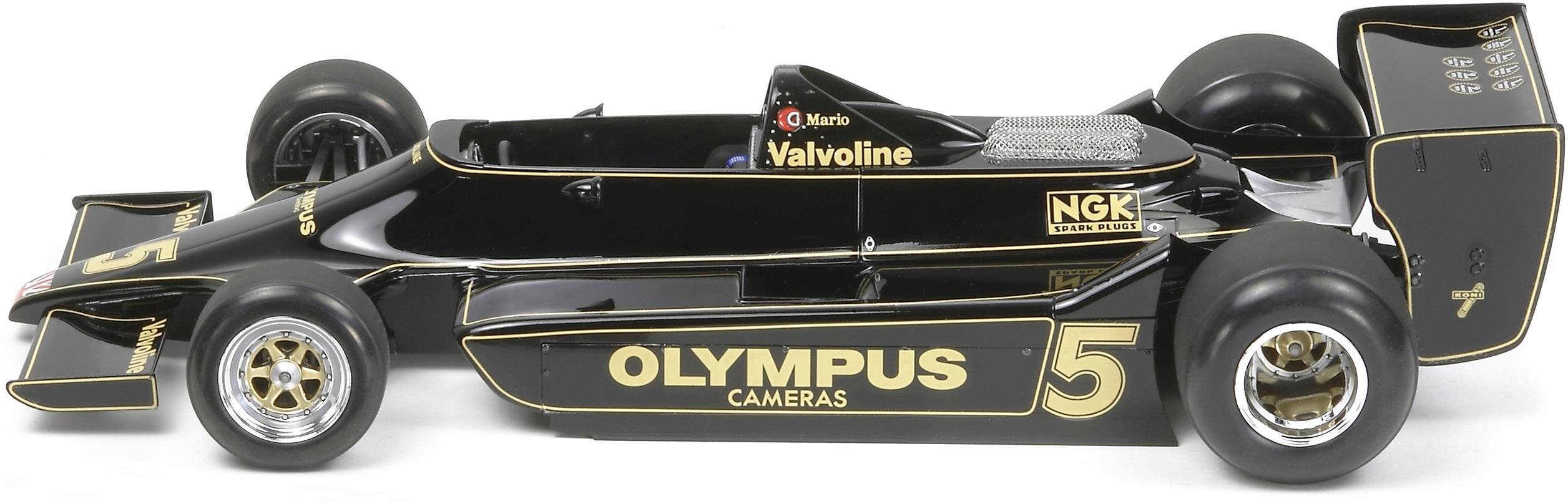 Voiture de Formule 1 noire avec des touches dorées et l'inscription 'Olympus Cameras', vue de côté. Le numéro de course 5 est visible.