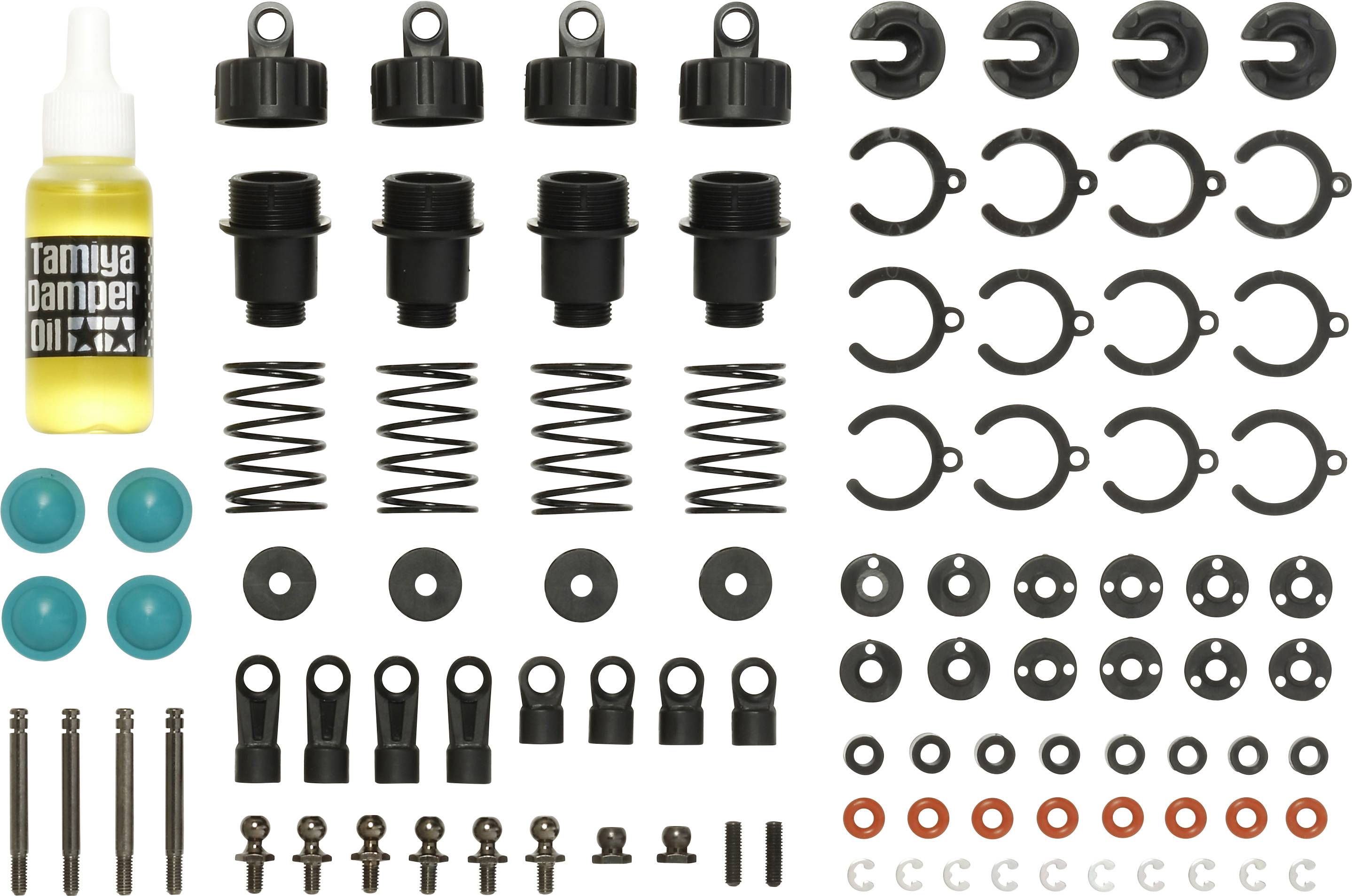 Kit d'amortisseurs comprenant une bouteille de gouttes d'huile, des ressorts, des tiges, des capuchons, des bagues et différentes petites pièces pour le montage de modèles réduits de véhicules.