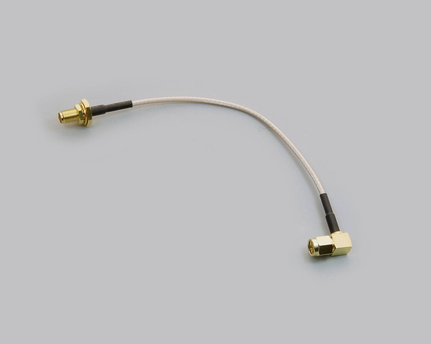 Câble coaxial avec deux connecteurs dorés, l'un droit et l'autre à angle droit, sur un fond gris.