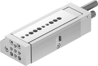 Un cylindre pneumatique rectangulaire en métal avec plusieurs trous sur le dessus et deux raccordements à l'arrière.