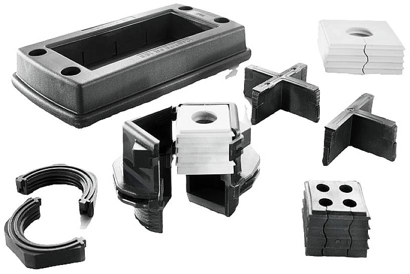 Plusieurs presse-étoupes et joints en plastique noir, partiellement assemblés et partiellement démontés, destinés à l'installation de câbles électriques.