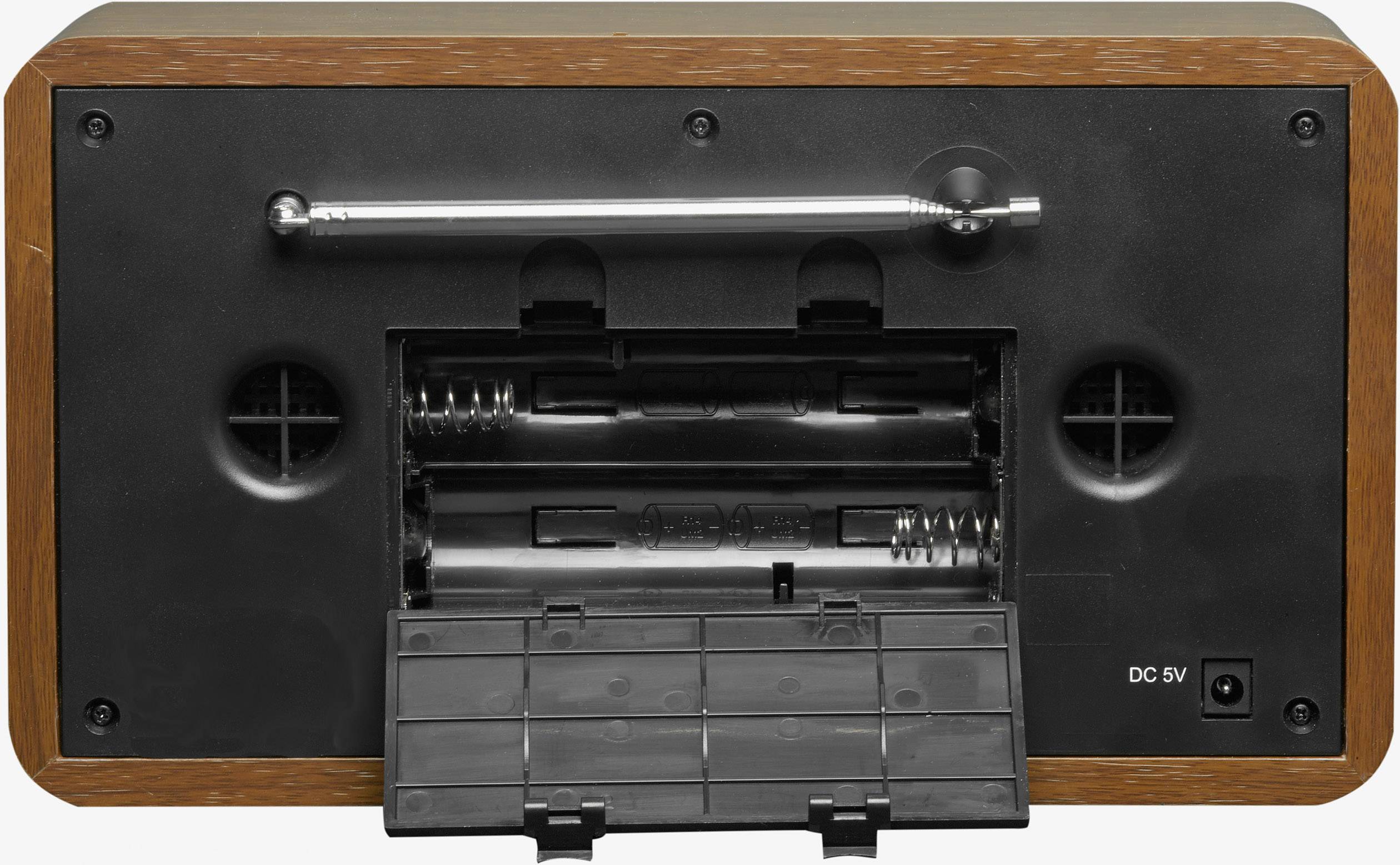 Arrière d'un poste de radio en bois avec le couvercle du compartiment à piles ouvert et une connexion pour DC 5V. Vue arrière avec antenne et haut-parleurs.