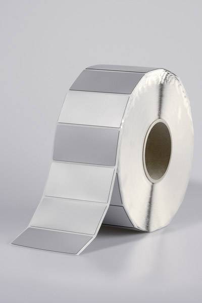 Un rouleau d'étiquettes autocollantes rectangulaires argentées, déroulé verticalement à moitié.