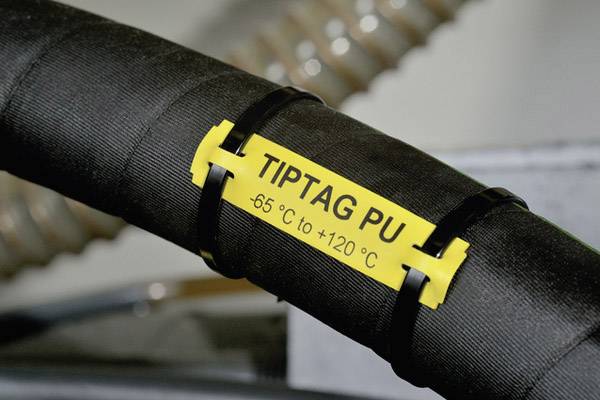 Câble noir avec étiquette jaune sur laquelle est inscrit 'TIPTAG PU -65 °C à +120 °C', fixé avec des colliers de serrage.