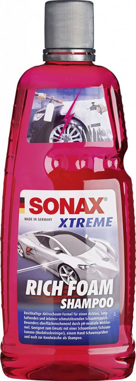 Bouteille rouge de shampooing auto 'SONAX Xtreme Rich Foam'. Autocollant avec voiture et mousse. Pour un nettoyage intensif et une action moussante.