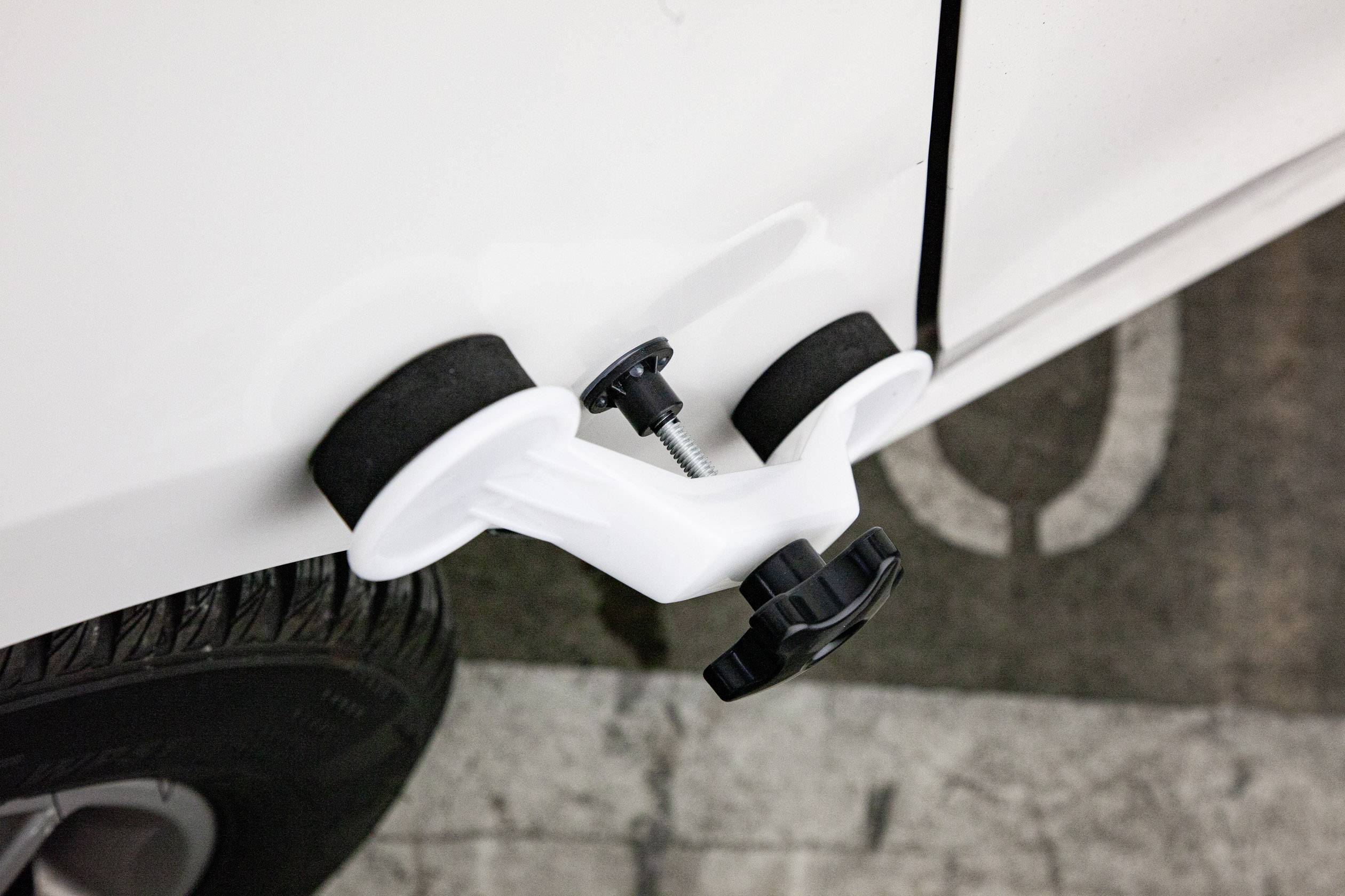 Un outil est appliqué sur la carrosserie d'une voiture pour enlever les bosses.