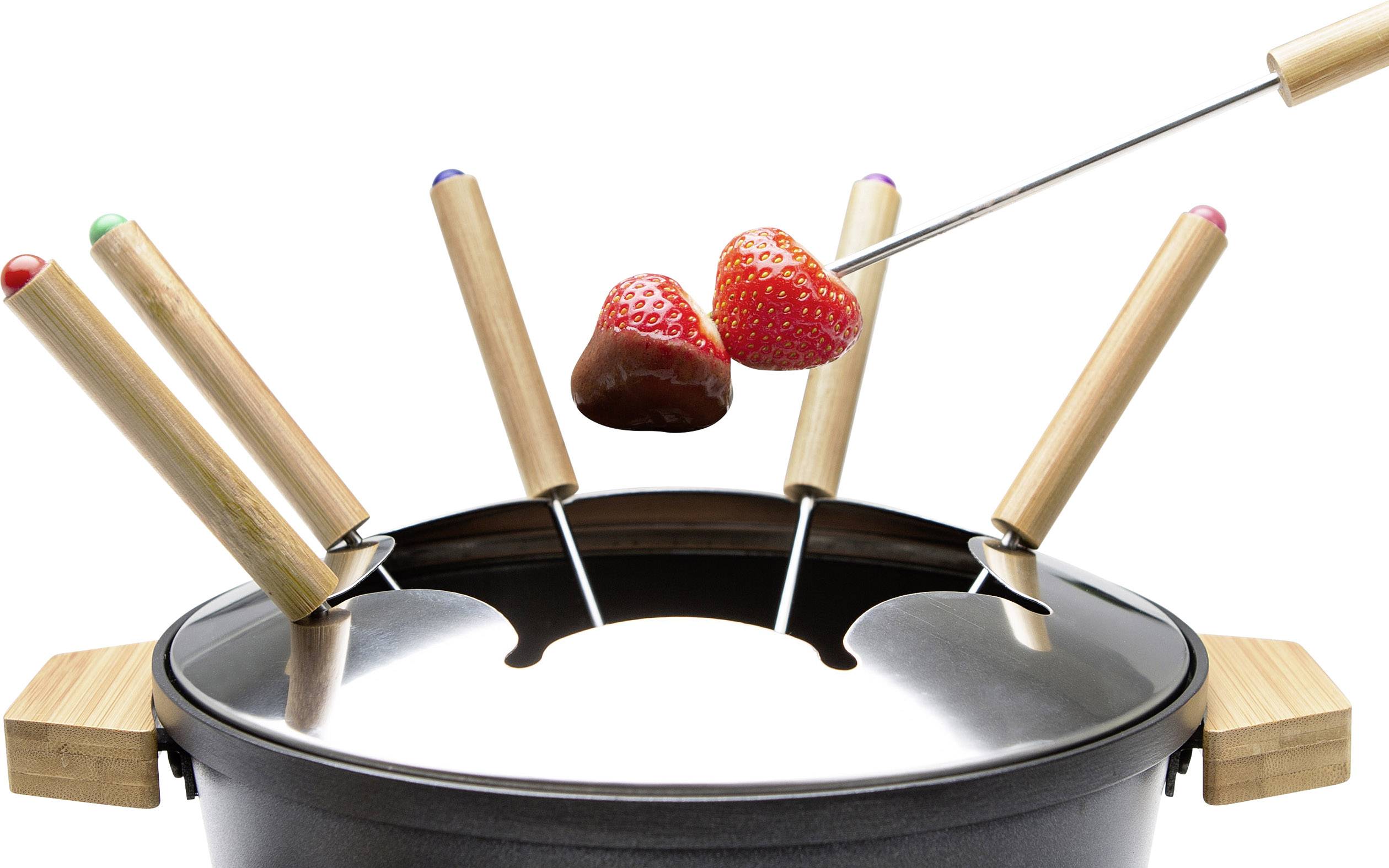 Un fondue avec des pics en bois sur lesquels se trouvent une fraise et une fraise enrobée de chocolat, sur un fond blanc.