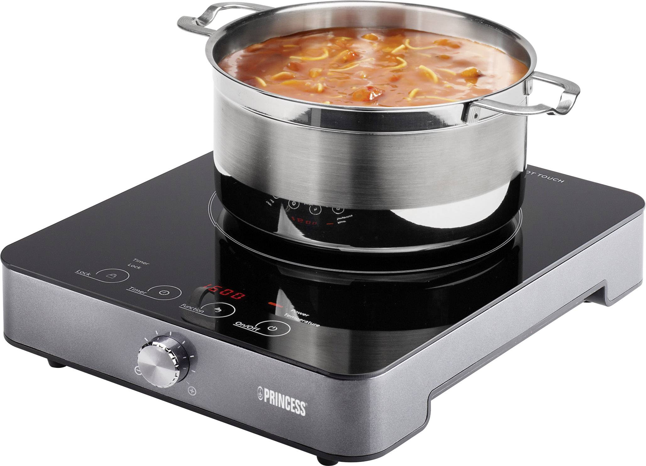 Une casserole de soupe rouge mijote sur une plaque à induction portable.
