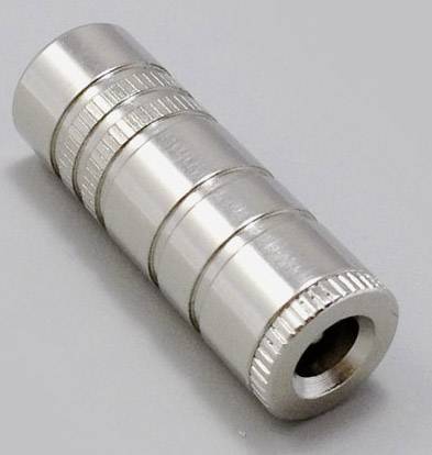 Un adaptateur métallique cylindrique argenté avec des bagues striées sur une surface grise.