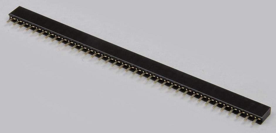 Une longue barrette noire avec des broches métalliques pour connexions électriques dans les circuits électroniques, sur un fond gris.
