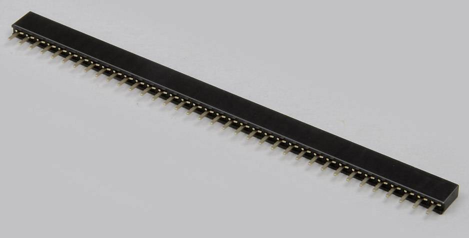 Une barrette de contacts noire avec de nombreuses broches métalliques, destinée à être utilisée dans des circuits électroniques, sur un fond gris.