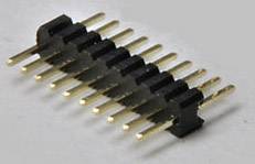 Un connecteur électrique noir avec plusieurs broches dorées alignées.