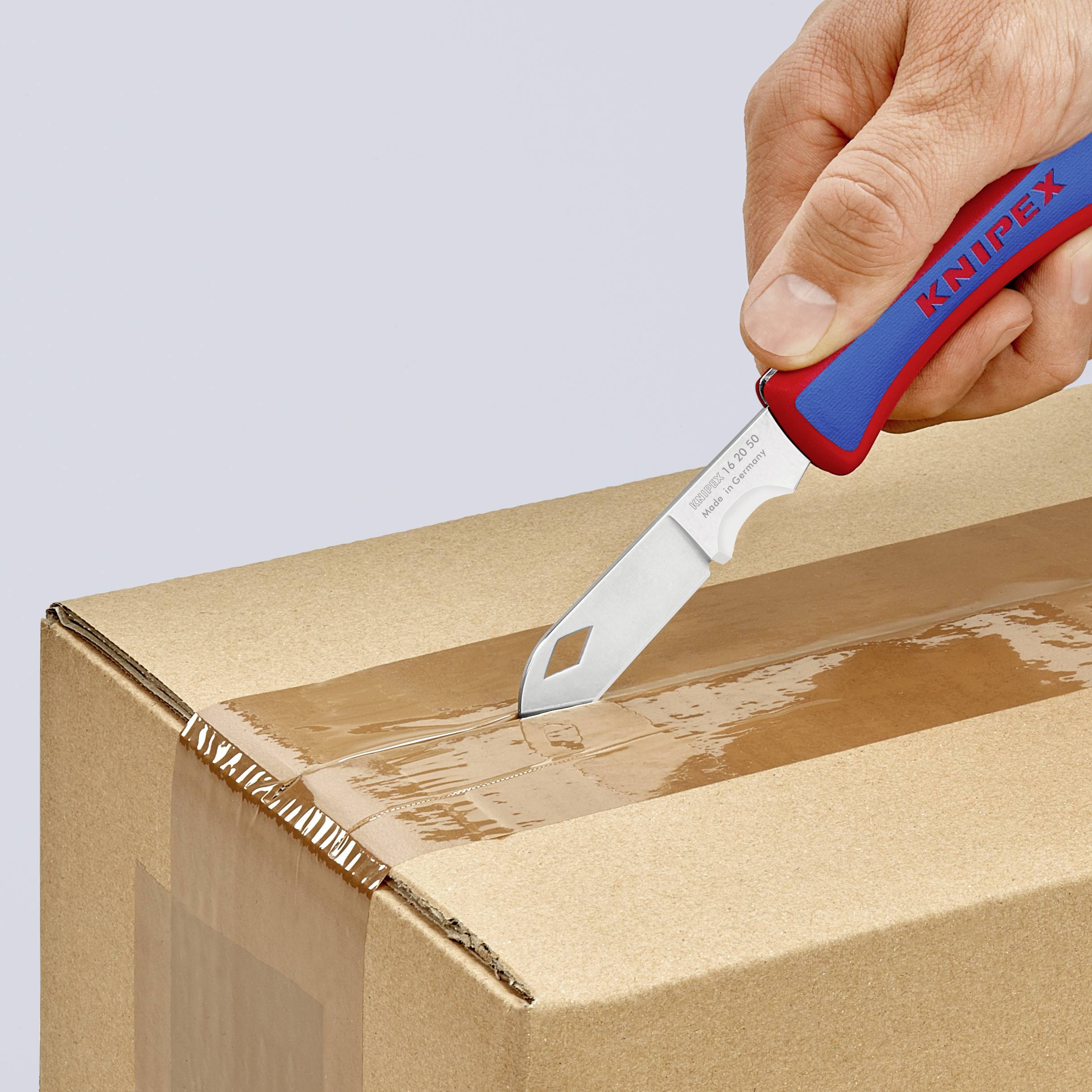 Une main utilise un couteau bleu et rouge pour ouvrir un carton.