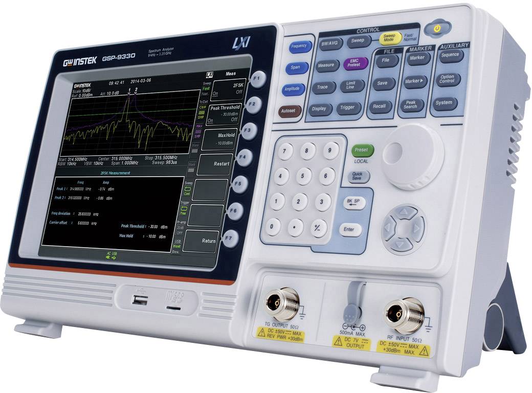Un oscilloscope avec un affichage numérique montre des données graphiques. Des touches et des connexions pour le contrôle de l'appareil sont visibles.