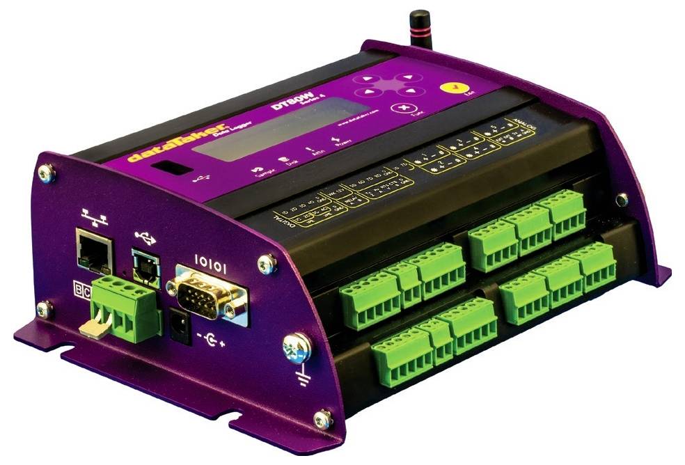 Boîtier électronique de commande de couleur violette avec plusieurs connecteurs verts, interfaces réseau et voyant LED en haut.