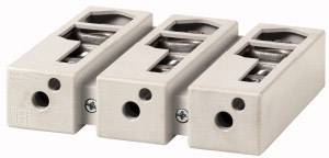 Trois bornes électriques beiges alignées, chacune équipée de deux vis et d'ouvertures, servant à connecter des lignes électriques.