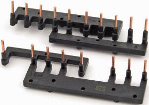 Plaque en plastique noir avec des broches en cuivre disposées en deux rangées. Cette configuration sert de connexion électrique.