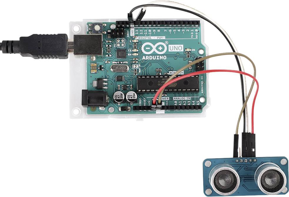 Carte Arduino Uno avec un capteur à ultrasons connecté. Les câbles relient les broches du capteur aux broches de l'Arduino, alimentation électrique en haut à gauche.