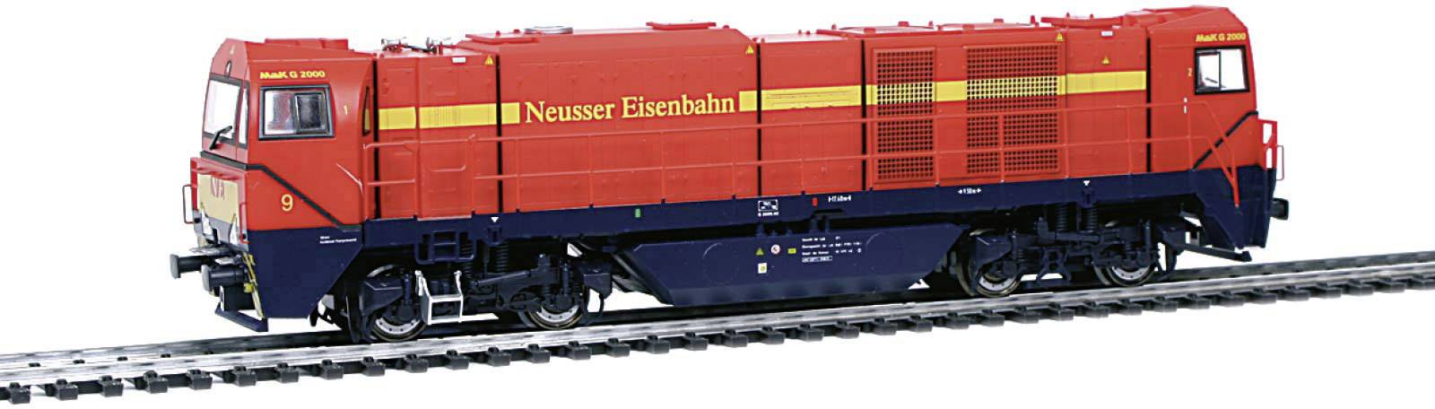 Une locomotive rouge de la Neusser Eisenbahn est stationnée sur les voies.