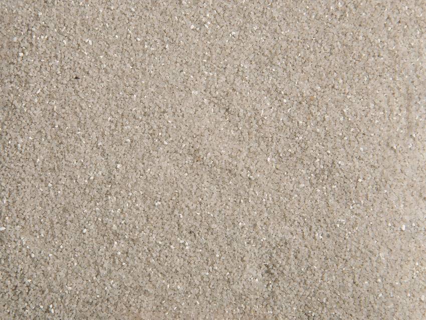 Gros plan sur du sable à grains fins et à surface uniforme.