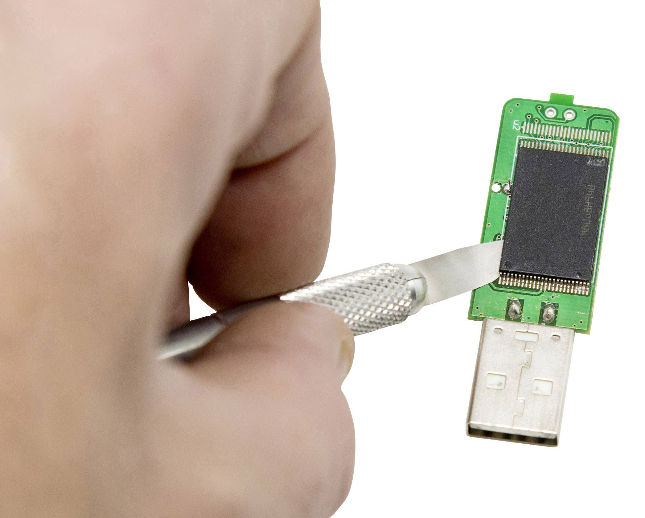 Une main tient un couteau et ouvre une clé USB pour rendre visible sa carte électronique interne et sa puce de mémoire.