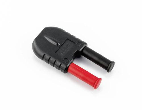 Un connecteur noir en plastique avec deux broches métalliques, l'une noire, l'autre rouge, est posé sur un fond blanc.