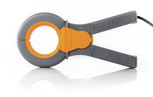 Un multimètre à pince gris avec des accents orange est posé sur une surface réfléchissante.