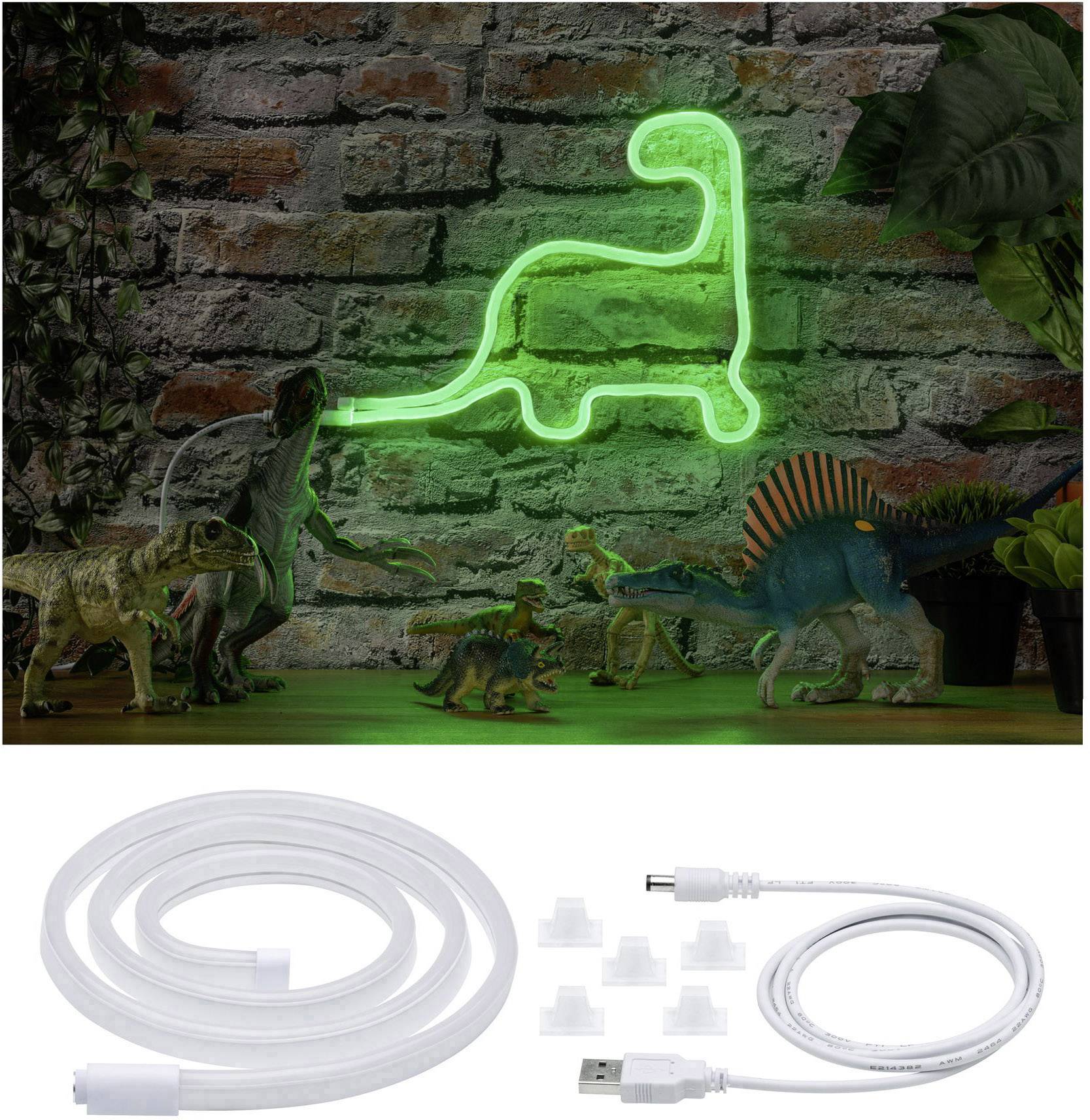 Un néon vert en forme de dinosaure sur un mur de briques, entouré de figurines de dinosaures. En dessous, un câble USB avec ses accessoires.