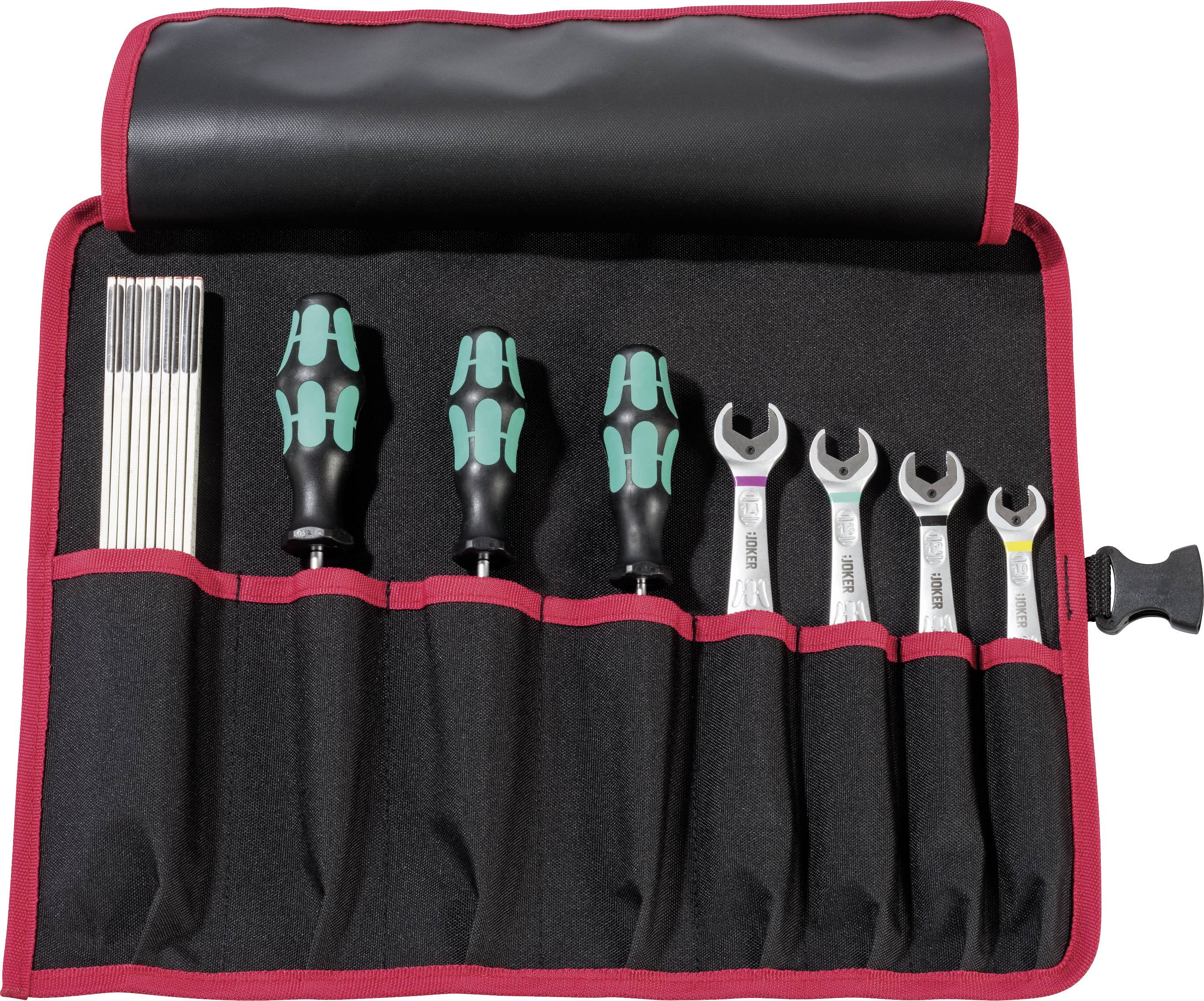 Un ensemble d'outils ouvert comprenant des tournevis et des clés mixtes dans un sac noir avec une bordure rouge.