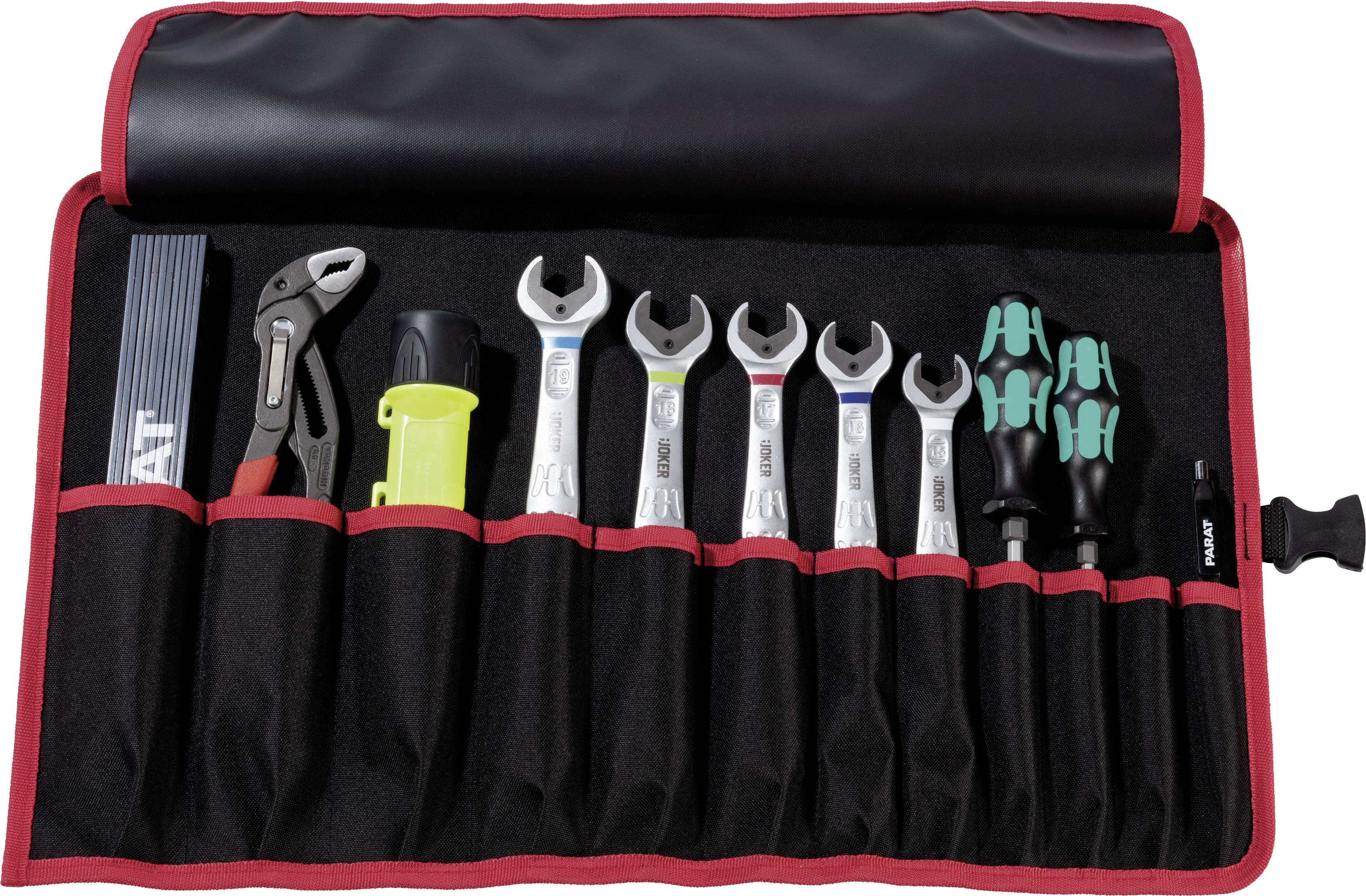 Un ensemble d'outils ouvert comprenant des clés, des tournevis, une pince et d'autres outils dans un sac rouge.