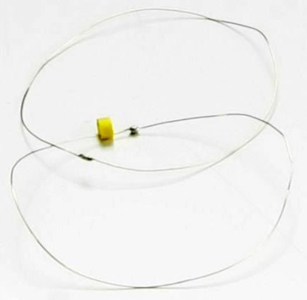 Un fil fin avec une partie centrale en plastique jaune, formé en un cercle ovale, sur un fond blanc.