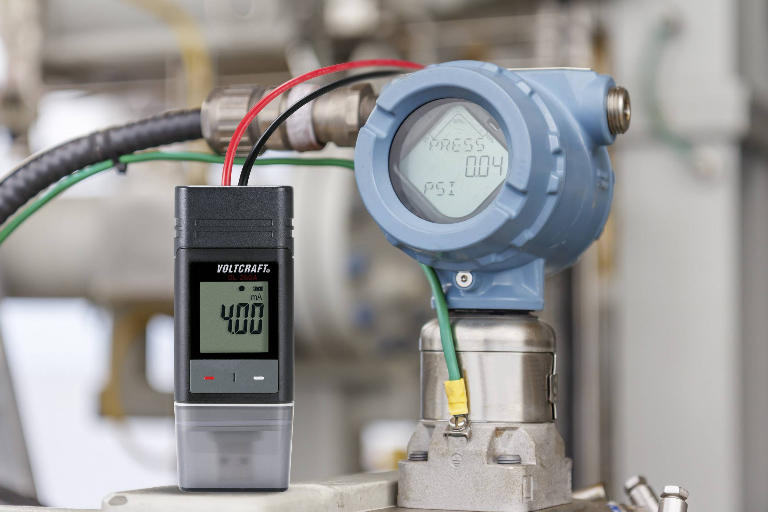 Un manomètre mesure 4,00 psi dans un environnement industriel. L'affichage numérique indique des valeurs de mesure précises pour la surveillance.