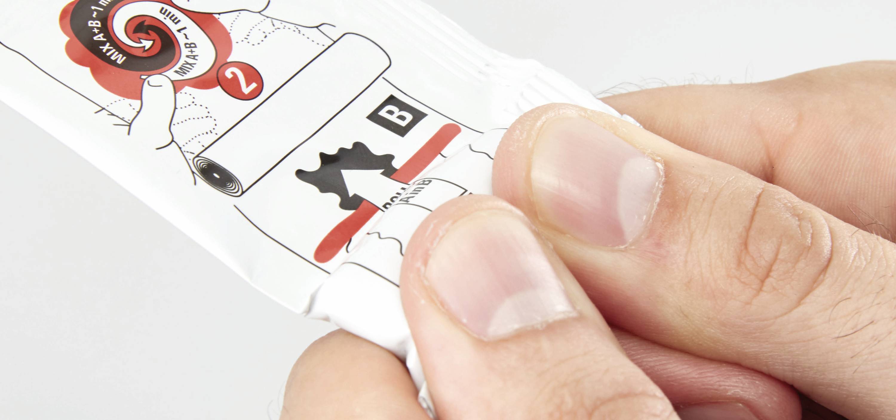 Une main presse un emballage avec des instructions d'utilisation. Une flèche indique l'endroit où il faut appuyer.