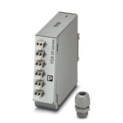Un appareil électrique gris et rectangulaire de la série 'FDX 20' avec plusieurs connexions, accompagné d'un petit presse-étoupe gris à proximité.