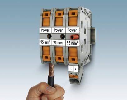 Une main tient un fil de cuivre qui est connecté à des blocs de bornes tripolaires portant l'inscription 'Power 95 mm²'.