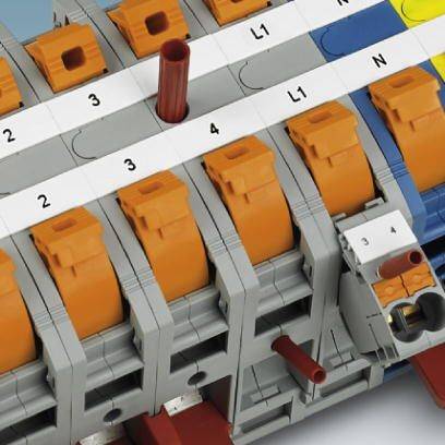 Bornes à ressort électriques multipolaires avec connexions numérotées, partiellement en orange, montées sur un rail de support.