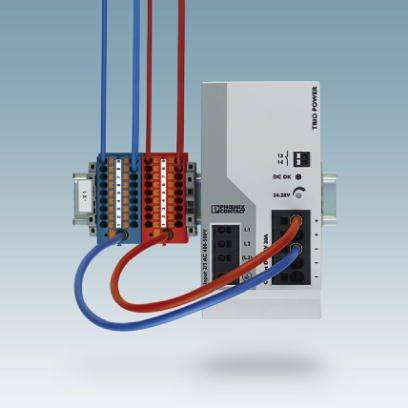Une unité de commande électrique avec plusieurs câbles branchés. À gauche se trouvent des câbles colorés, à droite la partie de contrôle.