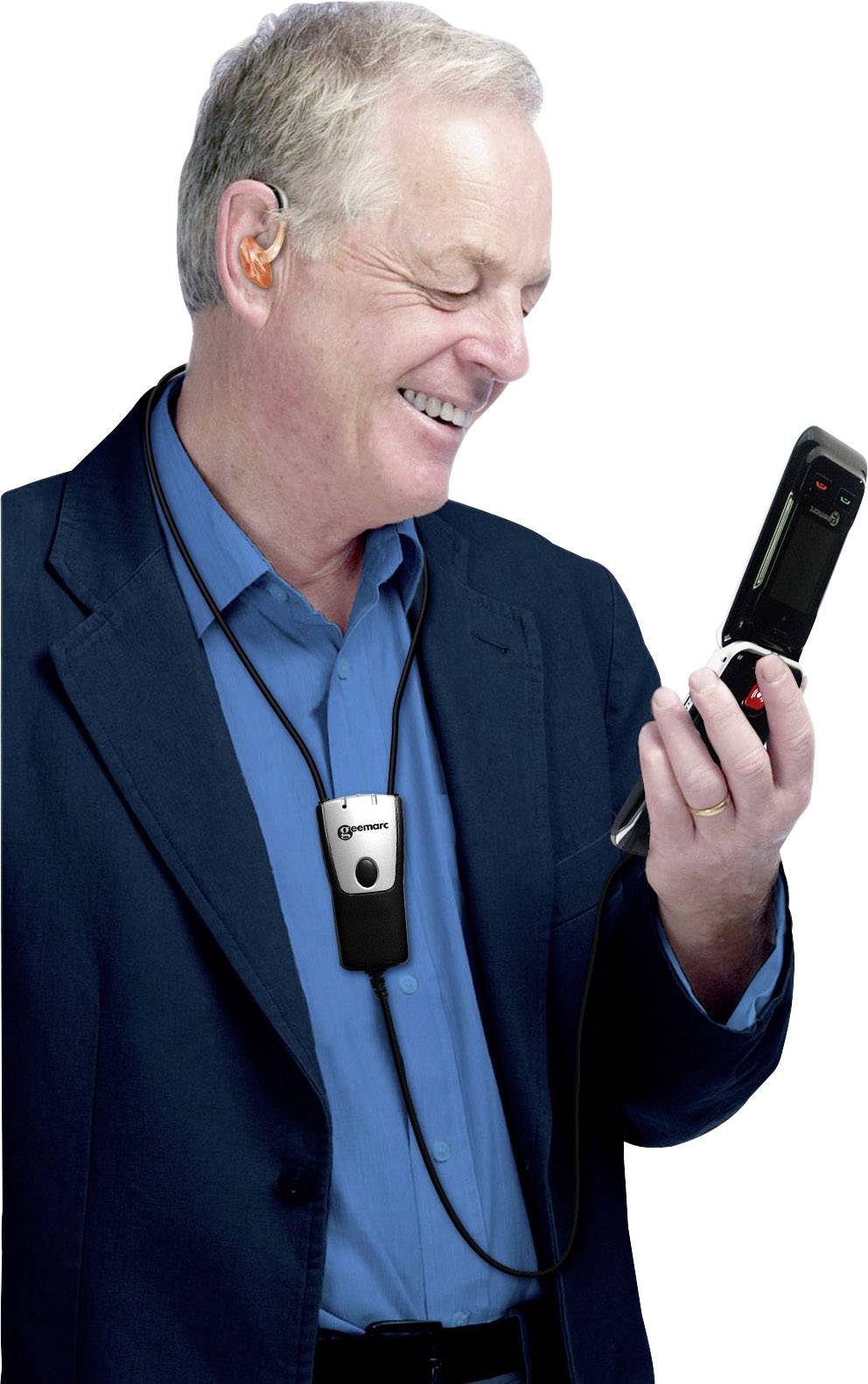 Un homme porte un appareil auditif et tient un téléphone mobile tout en souriant. Il est vêtu d'un costume bleu et d'une chemise bleue.