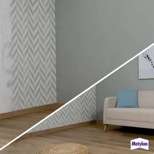 Ein Wohnzimmer, das Tapetenwände mit einem Vorher-Nachher-Design präsentiert; linke Seite ist einfarbig, rechte Seite hat einen gerahmten Bilderrahmen über einem Sofa.