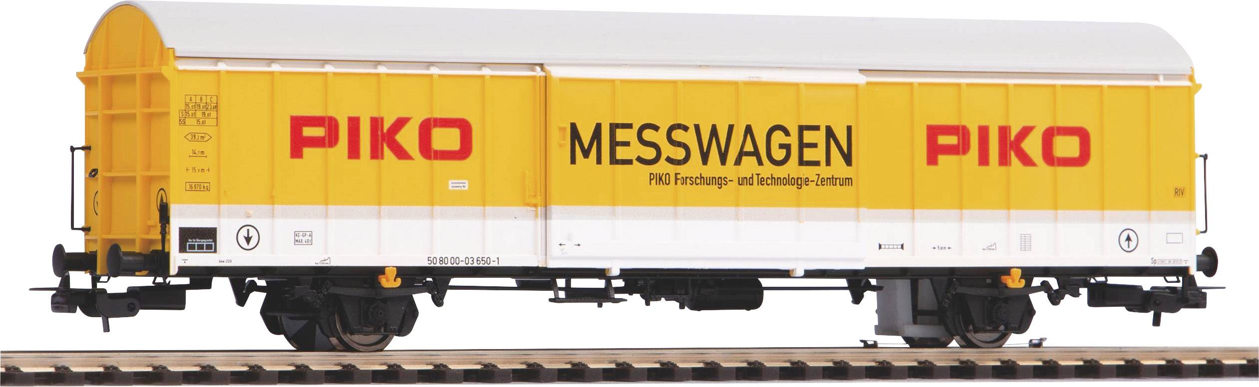 Un wagon de mesure jaune de la marque Piko sur des rails, portant l'inscription 'PIKO MESSWAGEN', est utilisé pour la recherche et la technologie.