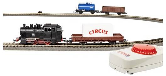 'A model train set featuring a black locomotive pulling a flatbed with a box labeled 