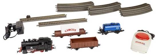 Ensemble de train avec rails, une locomotive, un wagon cargo « Cirque », un wagon-citerne bleu, un wagon ouvert marron, un adaptateur d'alimentation et une télécommande à bouton rouge.