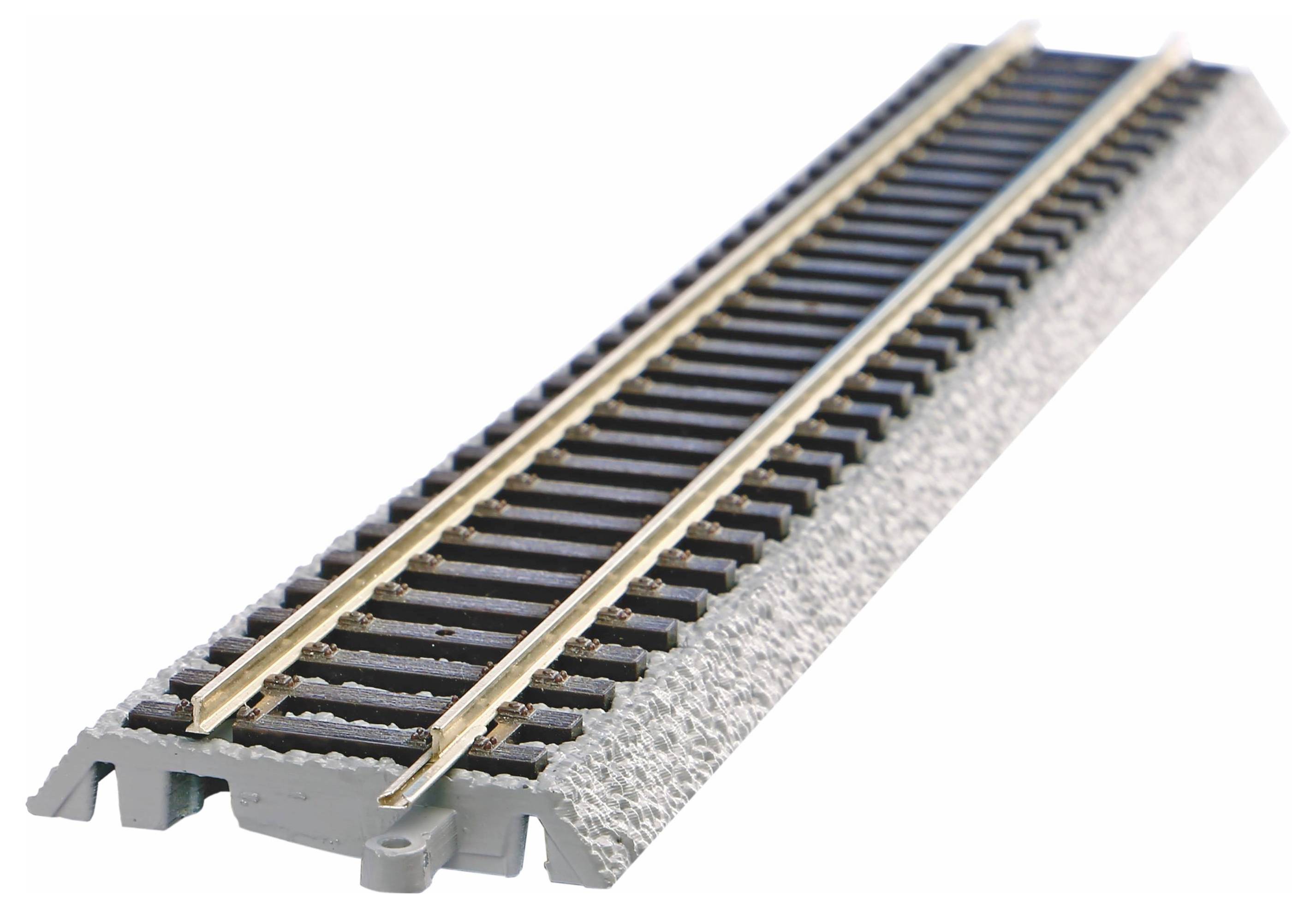 Un rail de train miniature en plastique avec deux rails en métal sur un lit de gravier gris, pris en perspective de l'avant vers l'arrière.