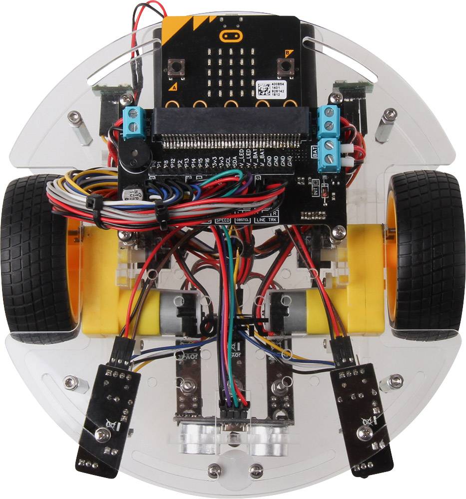 Un mini-robot sur roues avec des circuits électroniques et des capteurs visibles pour la programmation et la navigation, posé sur une base transparente.