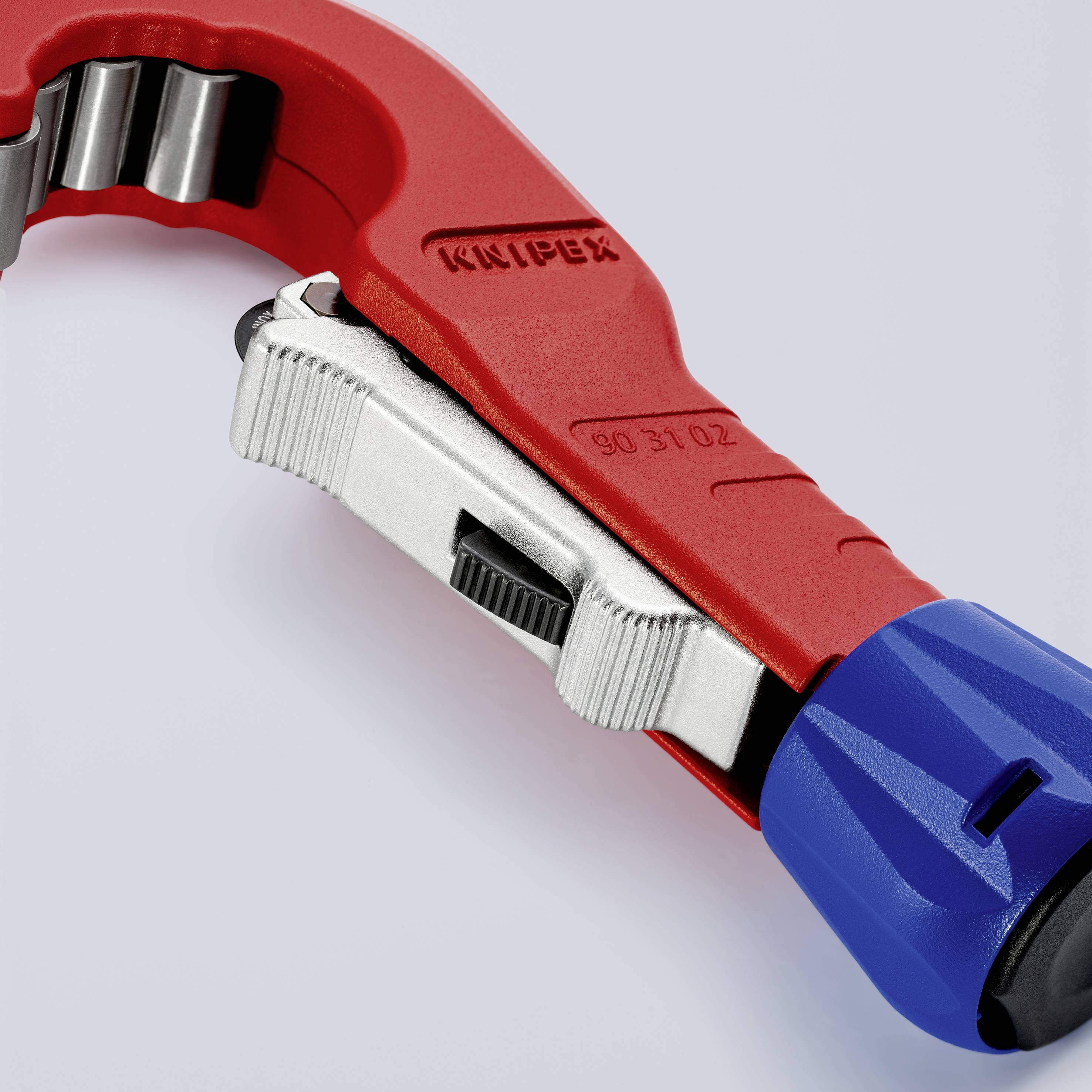 Coupe-tubes Rohrschneider en rouge et bleu, adapté pour couper des tubes en cuivre. La marque 'Knipex' est visible dessus.
