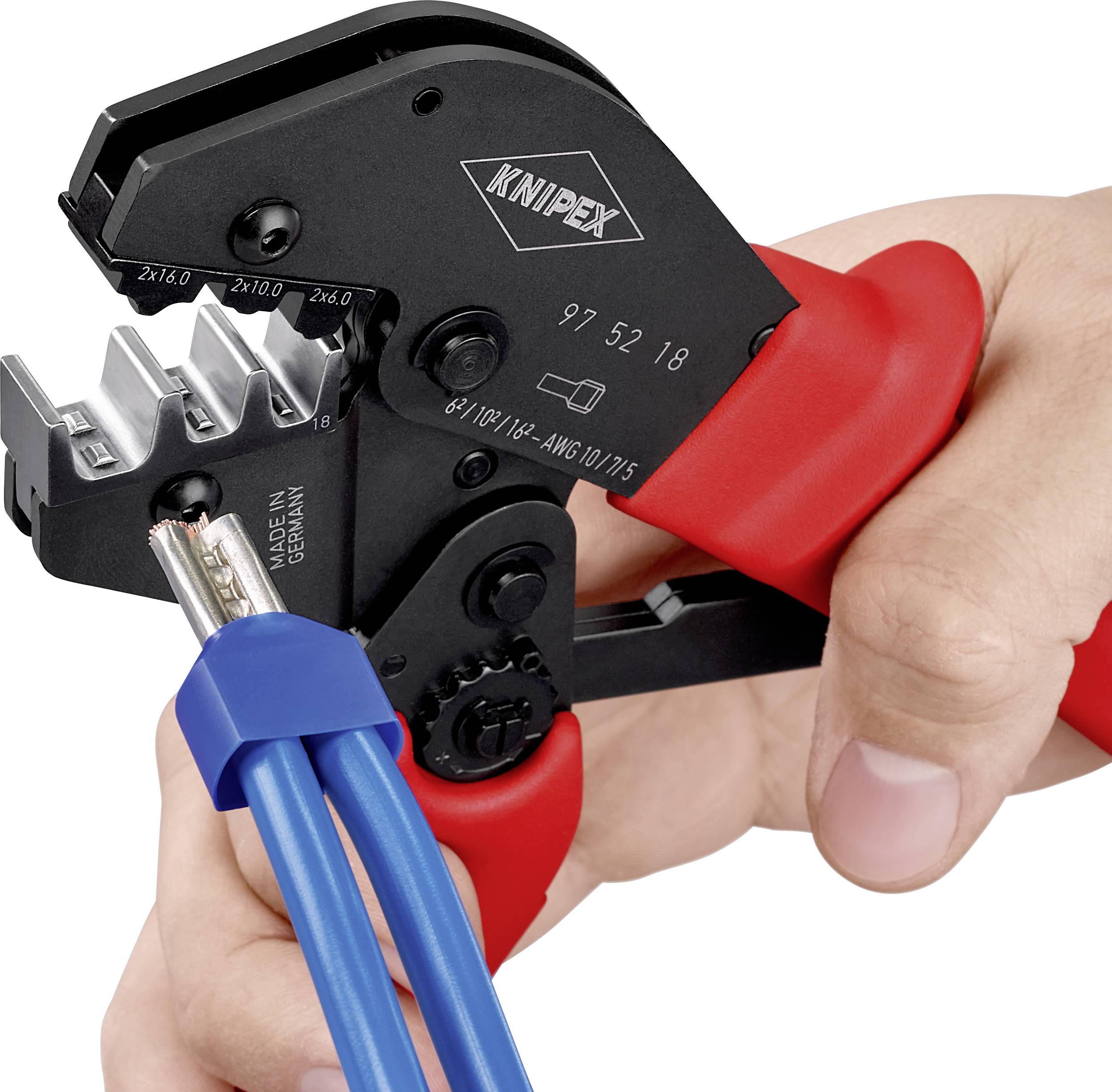 Une main tient une pince à sertir rouge de la marque Knipex, qui travaille un câble.