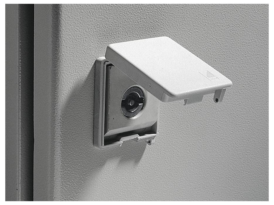 Un verrou de sécurité sur une surface gris clair. Le couvercle est soulevé et un trou de serrure est visible.