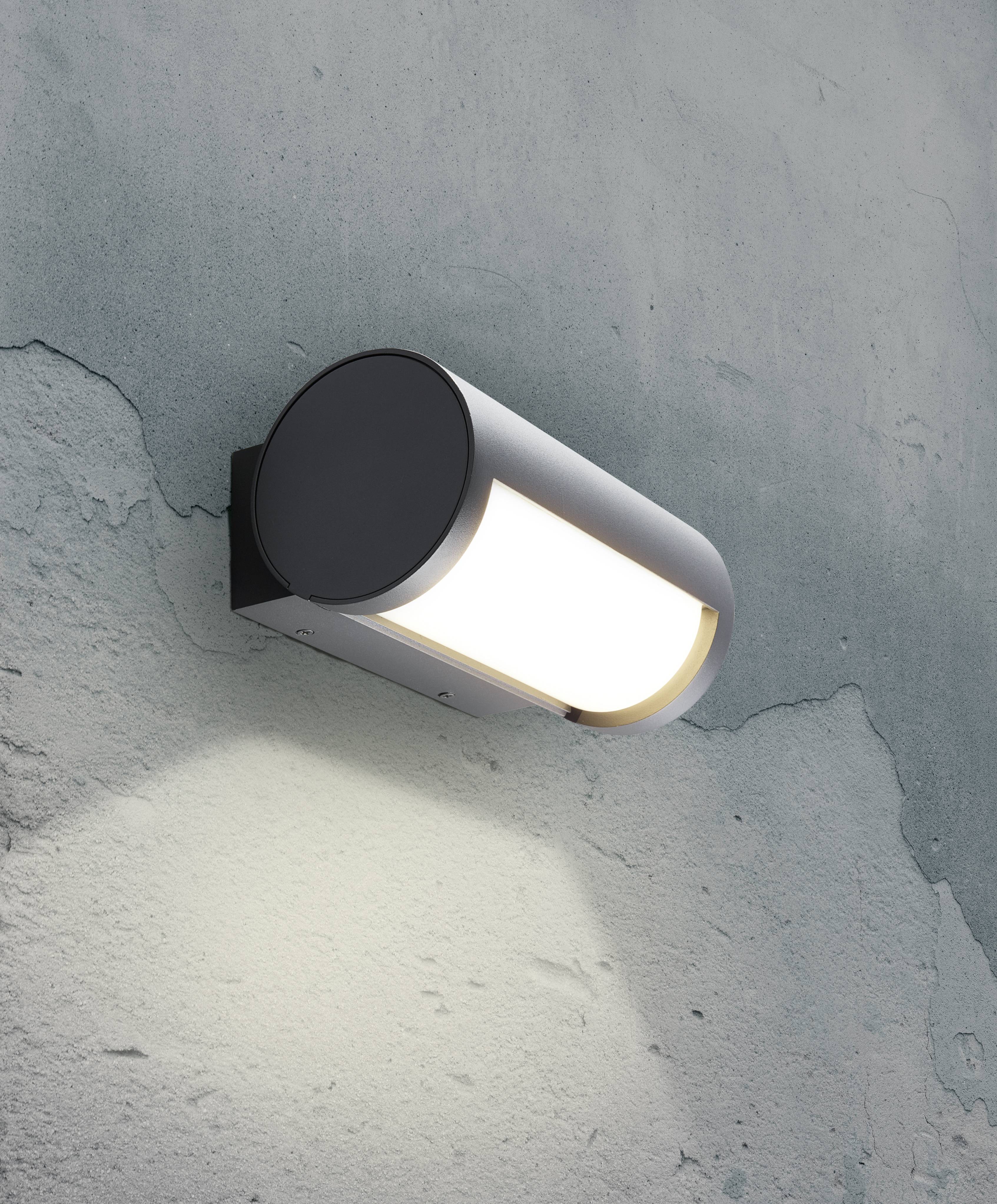 Lampe murale moderne au design épuré éclairant uniformément une surface rugueuse de type béton.